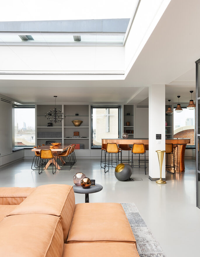 A reception room with a large skylight, internal glass doors and stylish furnishings