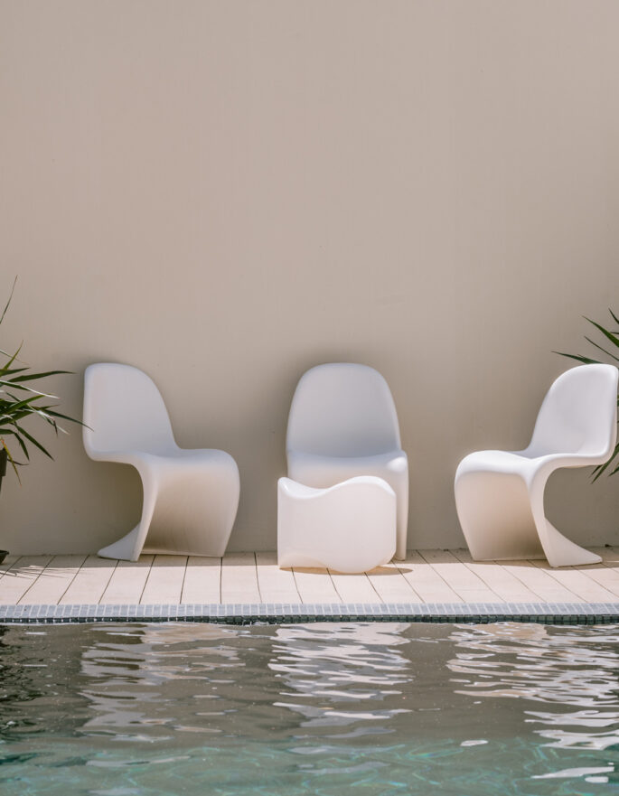 Sophisticated outdoor furniture reflected in the pool of a villa to buy in Ibiza