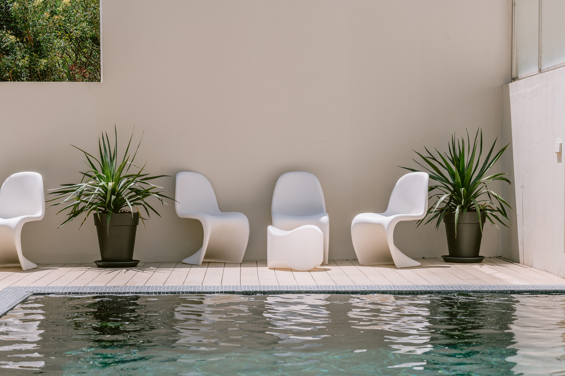 Sophisticated outdoor furniture reflected in the pool of a villa to buy in Ibiza