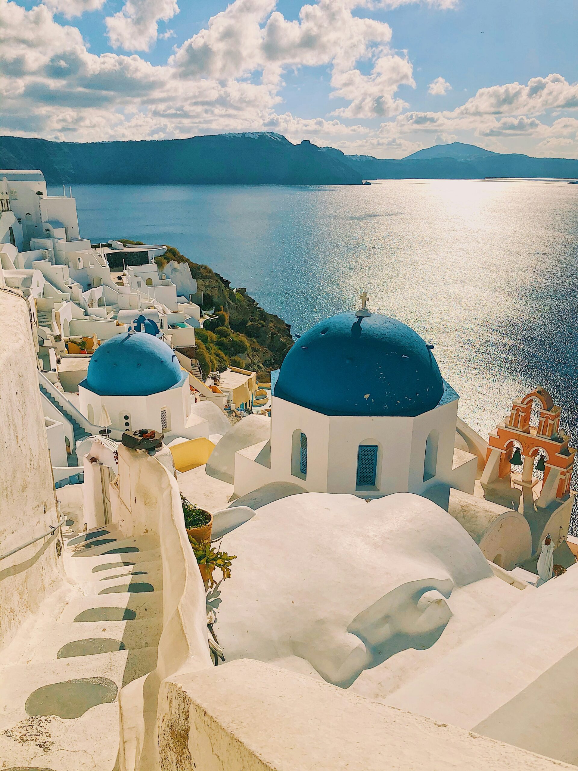 The iconic skyline of Santorini with blue and white buildings, for Barnes International luxury real estate