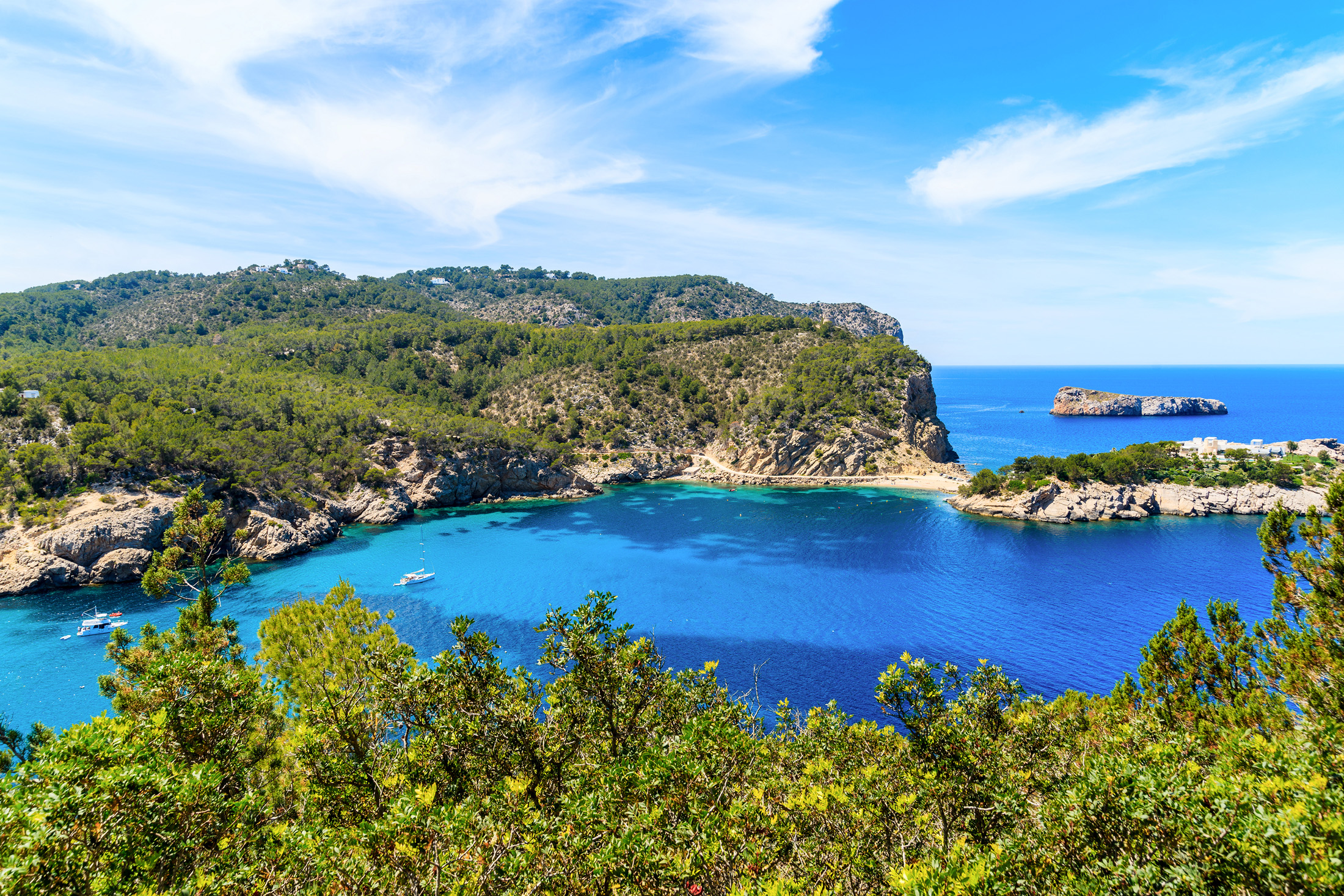 View of stunning sea bay with boats on water on Ibiza northern coast, Spain