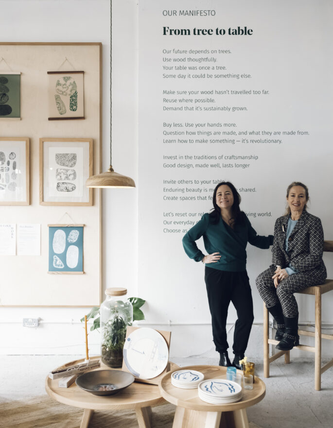 Two business owners in front of a manifesto in a design studio