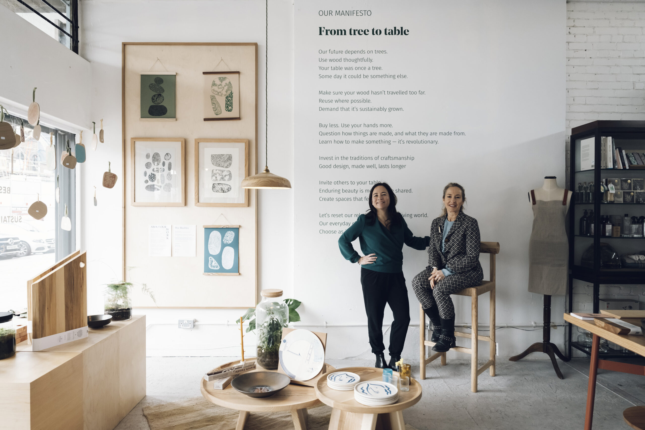 Two business owners in front of a manifesto in a design studio