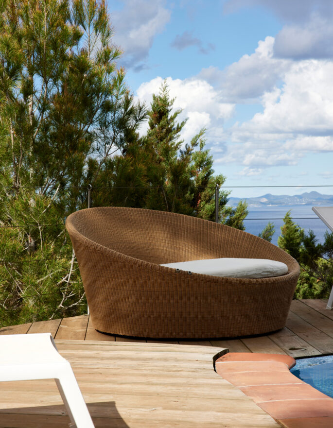 Stylish outdoor furniture backdropped by the sea, at a luxury villa in Ibiza
