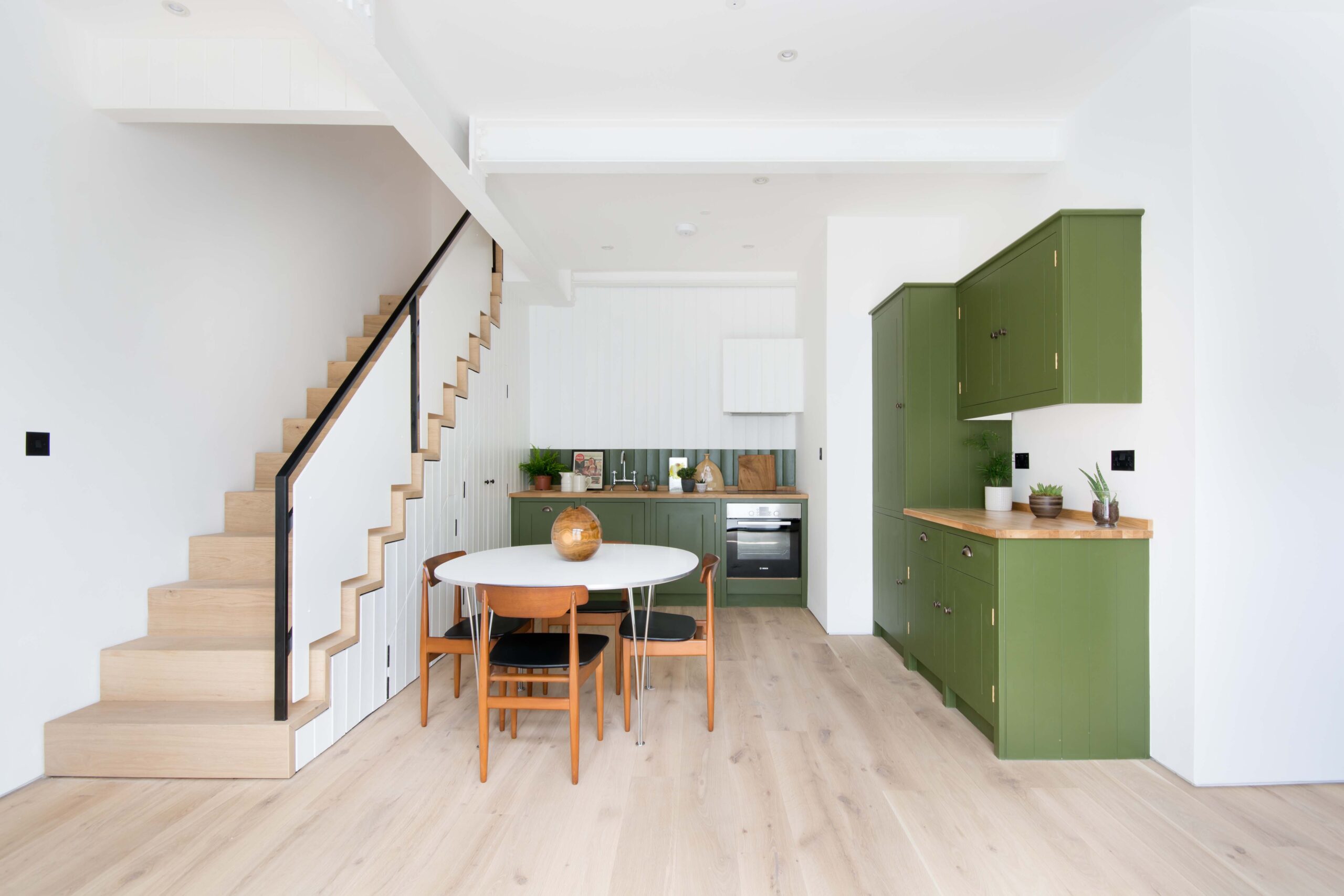 Godolphin Road Shepherd's Bush W12 open-plan kitchen and dining room with green cabinets and white walls
