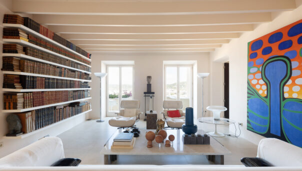 Colourful artwork and a wall of books flank the contemporary living space of a luxury townhouse for sale in Ibiza