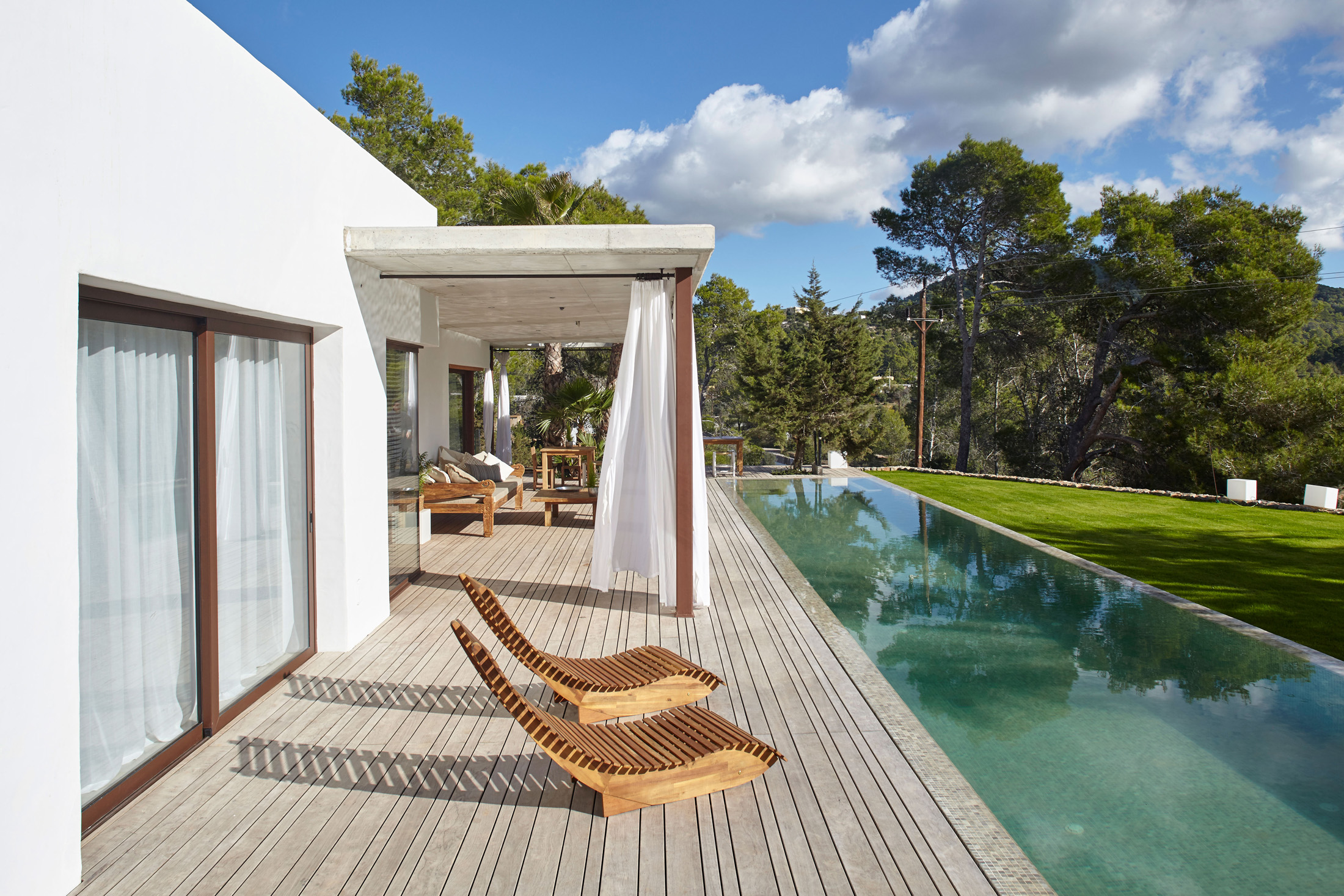 Pool furniture lounges in the sun at a luxurious Ibizan villa