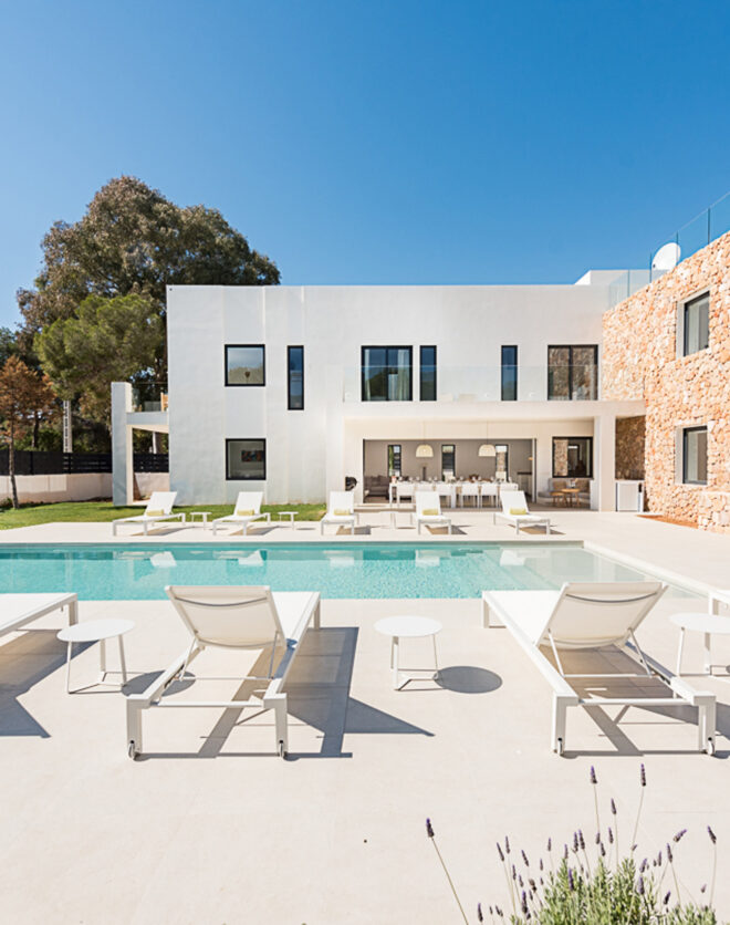 Pool furniture lounges in the sun next to a luxury villa to buy in Ibiza