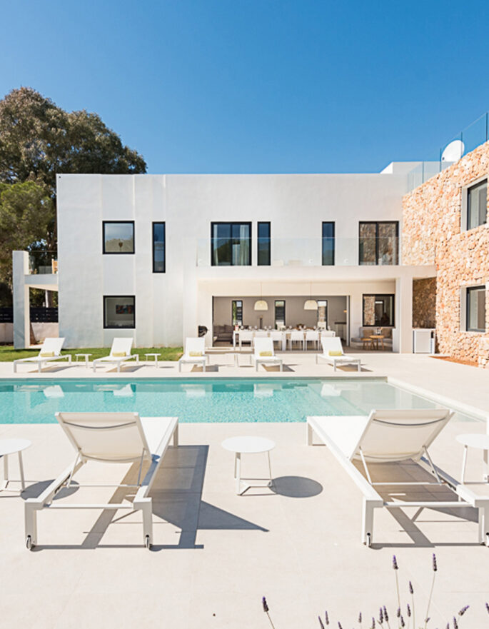 Sun loungers next to a pool at a luxury villa for sale in Ibiza