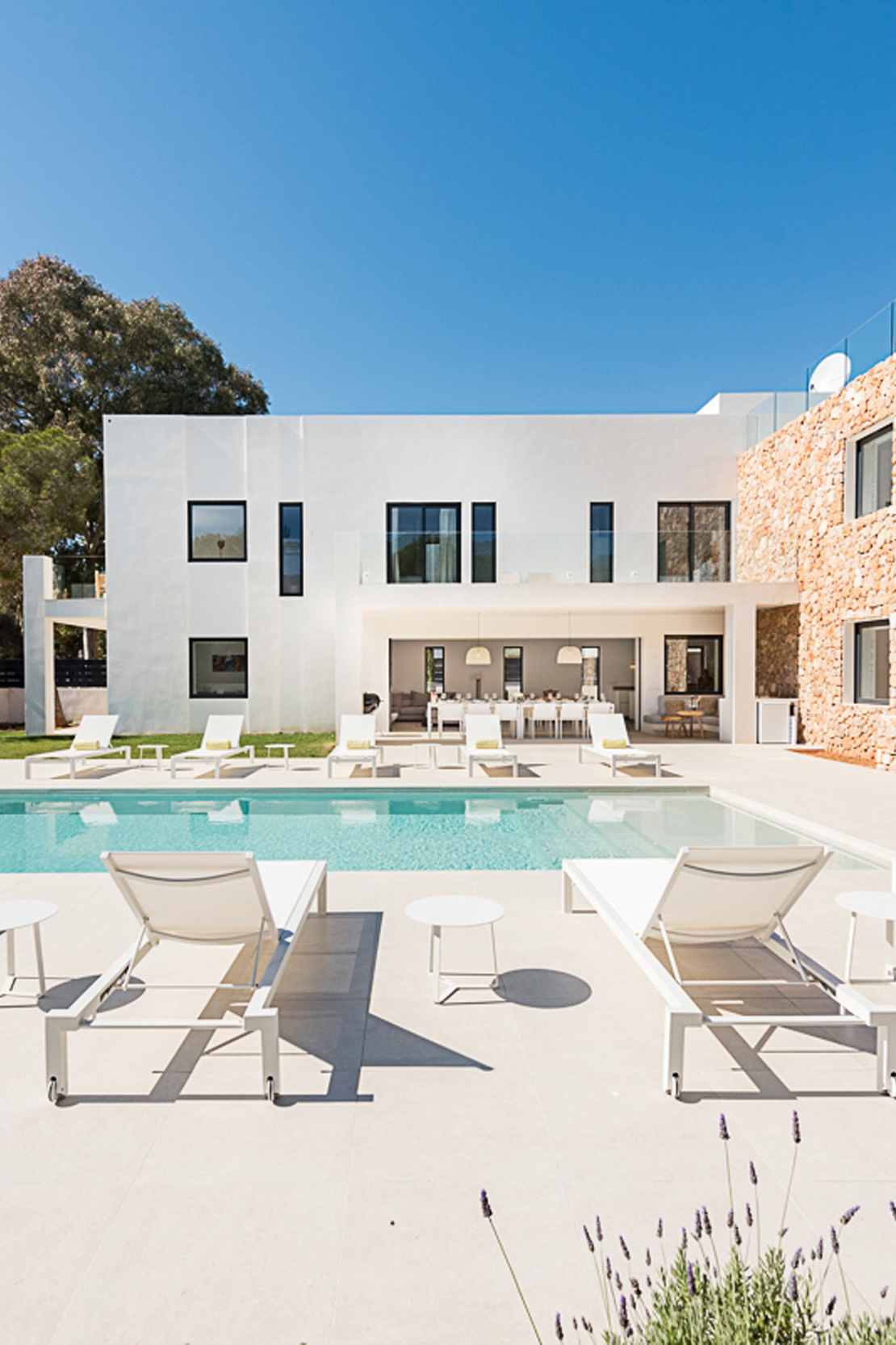 Sun loungers next to a pool at a luxury villa for sale in Ibiza