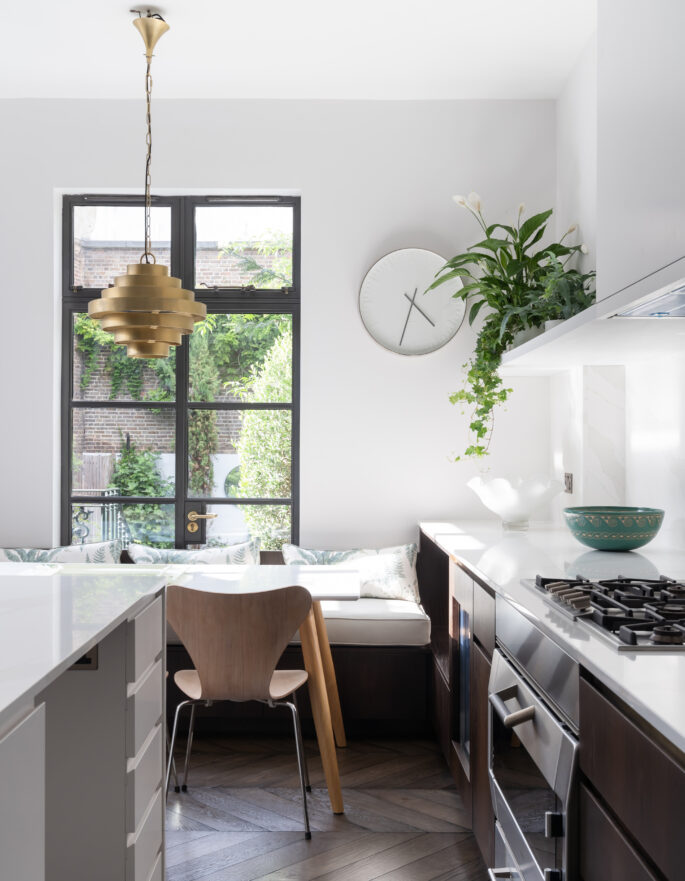 A modern white kitchen with a Crittall window