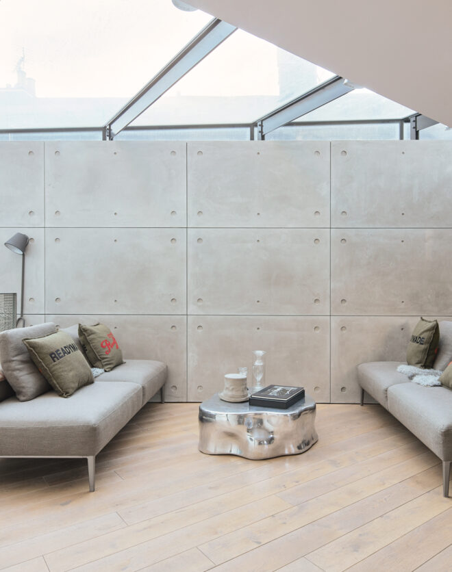 Sky-lit reception room with smooth concrete walls in a three-bedroom home for sale in North Kensington