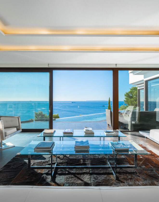Villa for sale in Ibiza with a stylish contemporary living room featuring concealed strip lighting and panoramic sea views