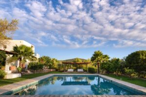 Candy floss clouds reflected in the pool of a luxury rental villa in Ibiza