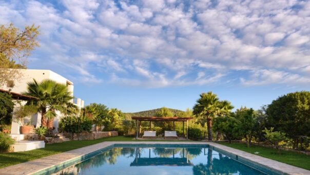 Candy floss clouds reflected in the pool of a luxury rental villa in Ibiza