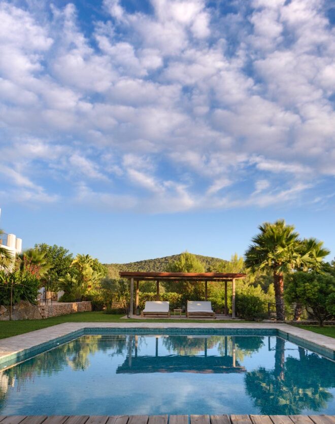 Candy floss clouds reflected in the pool of a luxury rental villa in Ibiza