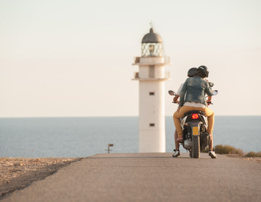 couple ride a bike by the lighthouse