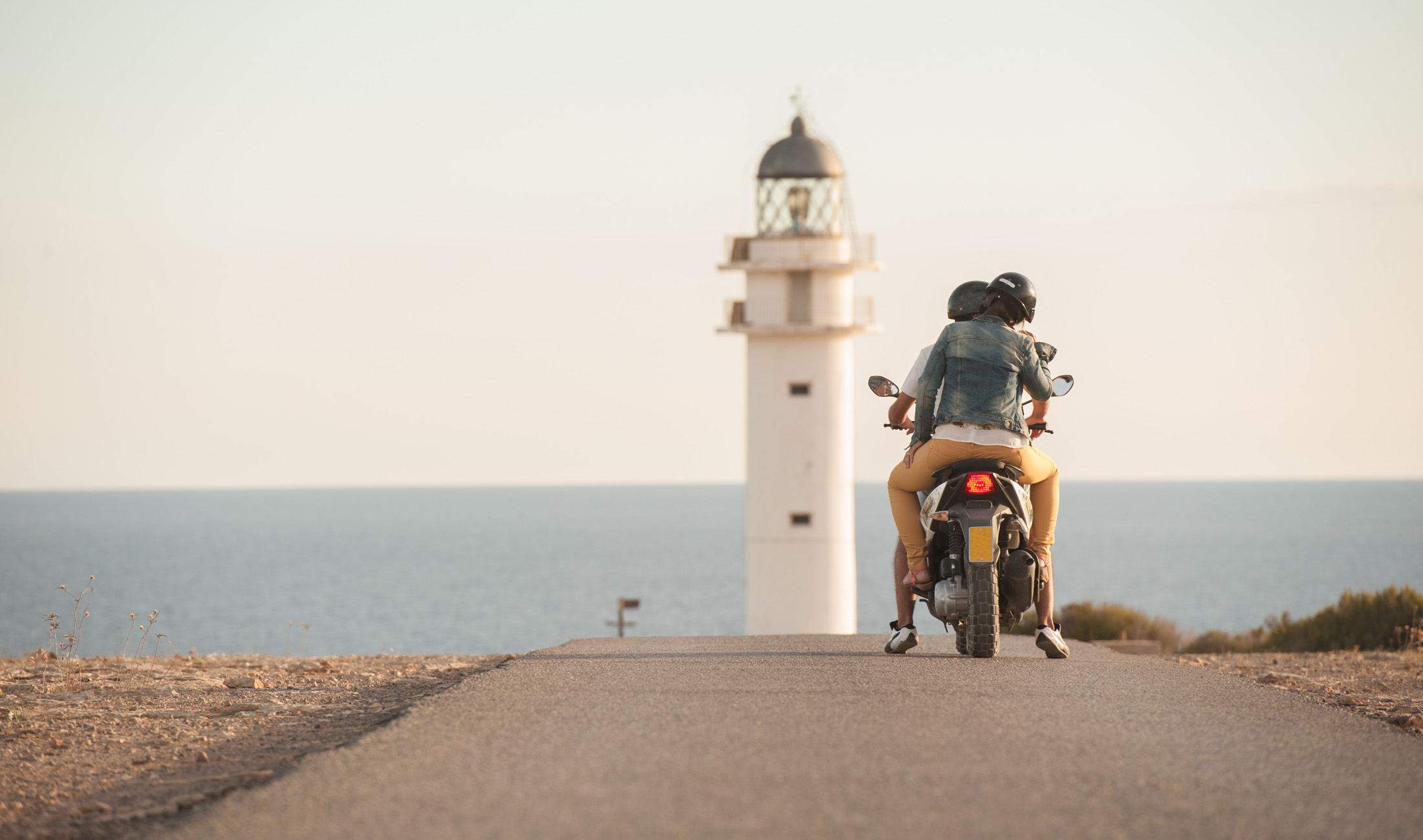 couple ride a bike by the lighthouse
