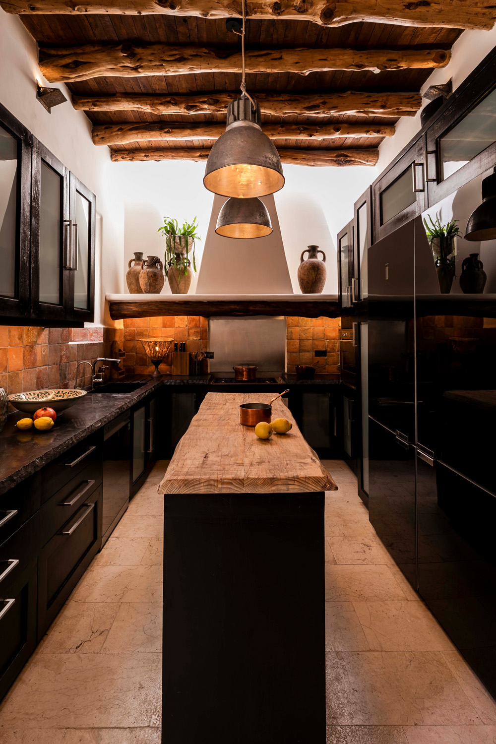 A dark, dramatic and rustic kitchen of a rental villa