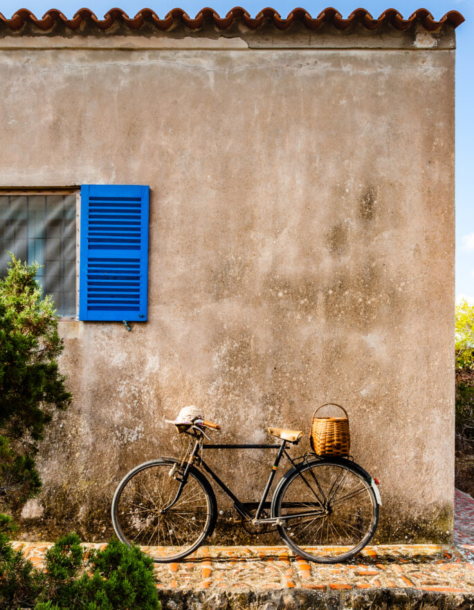 Old bicycle leaning against a neglected wall at sunset. Formentera, Balearic islands.