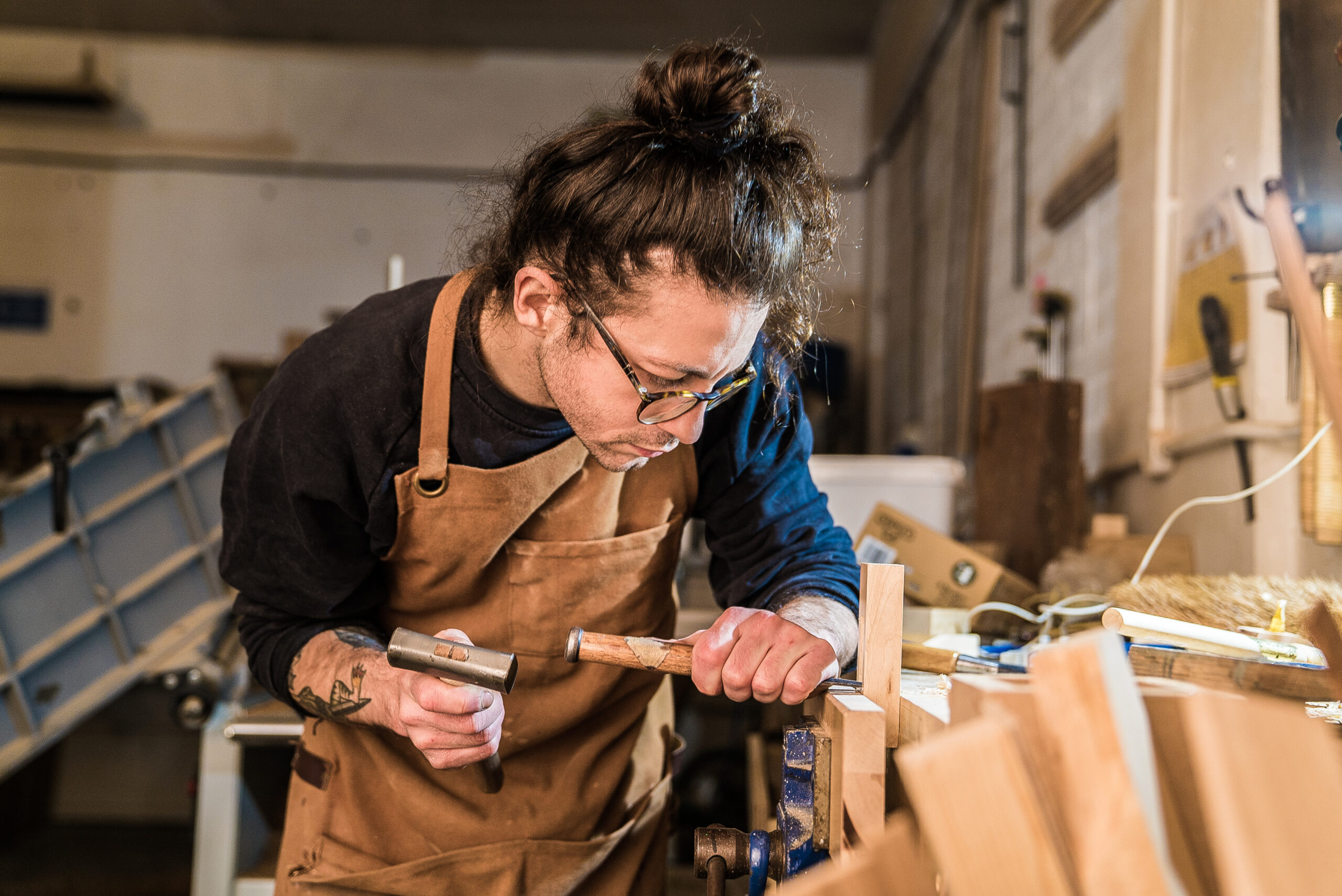 A woman skillfully carves a piece of wood