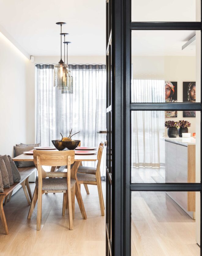 Contemporary open-plan kitchen and dining room with Crittall glass doors in a three-bedroom Holland Park duplex for sale