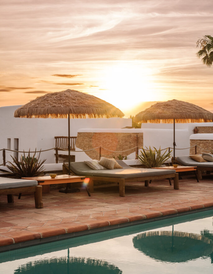 Sunset behind the pool of a rustic rental villa in Ibiza