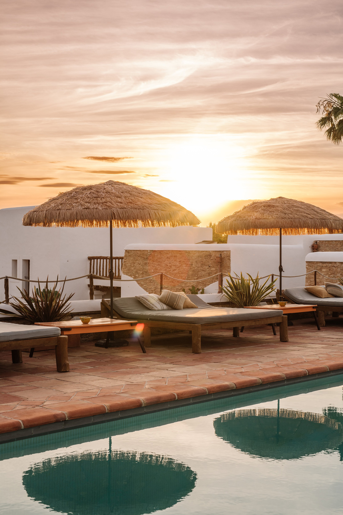Sunset behind the pool of a rustic rental villa in Ibiza