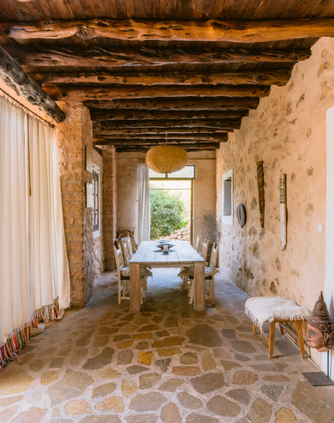 Unshaped Sabina beams crown the rustic dining space of a luxury home for sale in Ibiza
