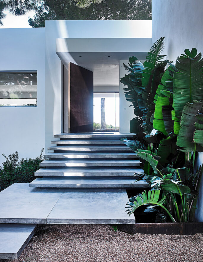 The entrance of a luxurious, white-painted villa in Ibiza