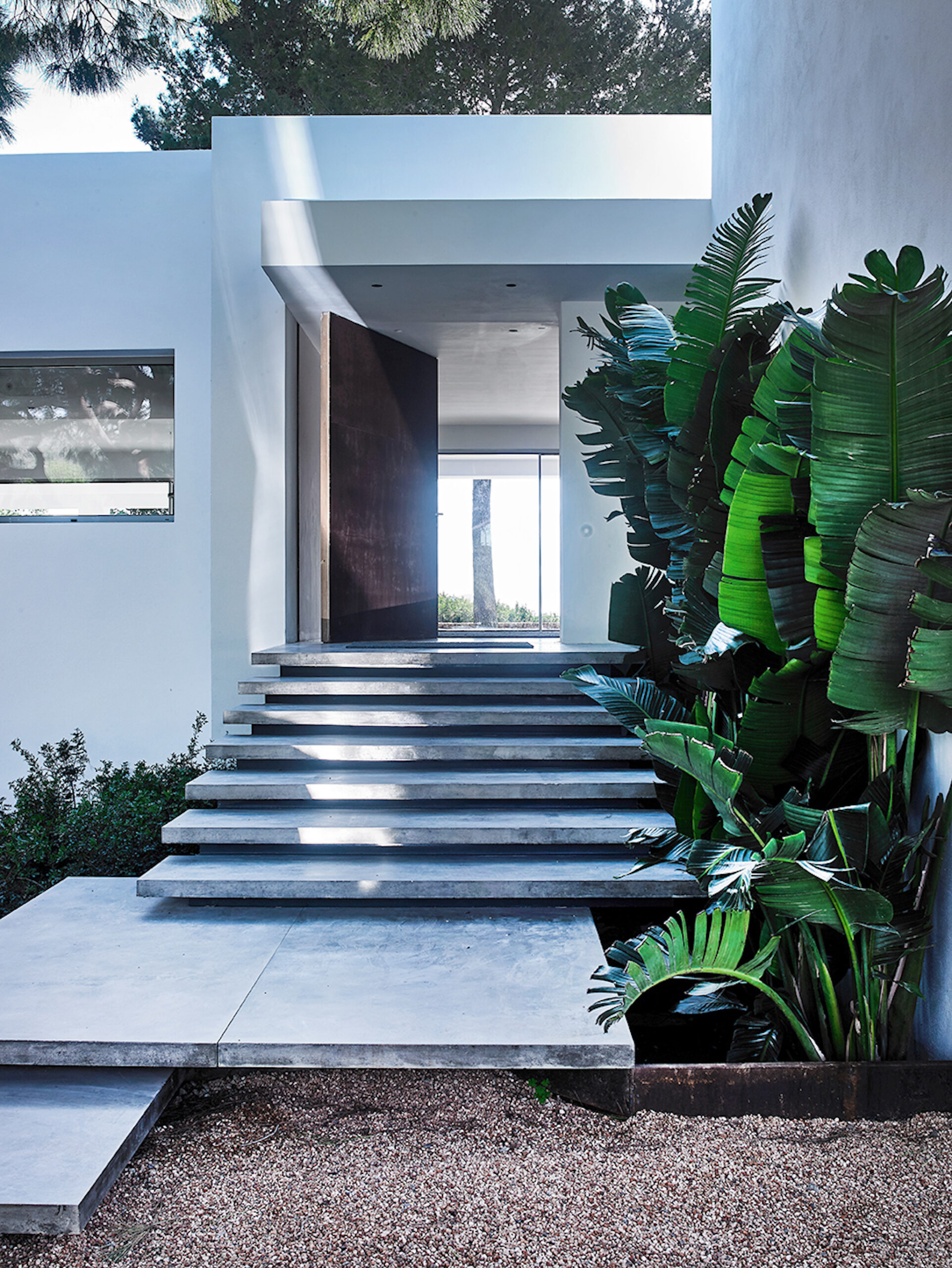 The entrance of a luxurious, white-painted villa in Ibiza