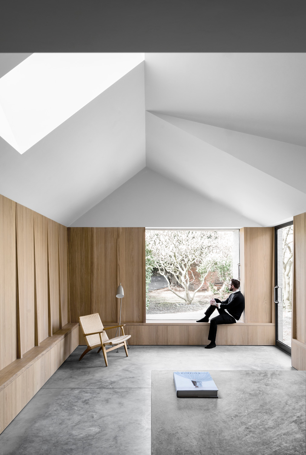 Man sitting in Kew House by McLaren.Excell - luxury contemporary architecture in London
