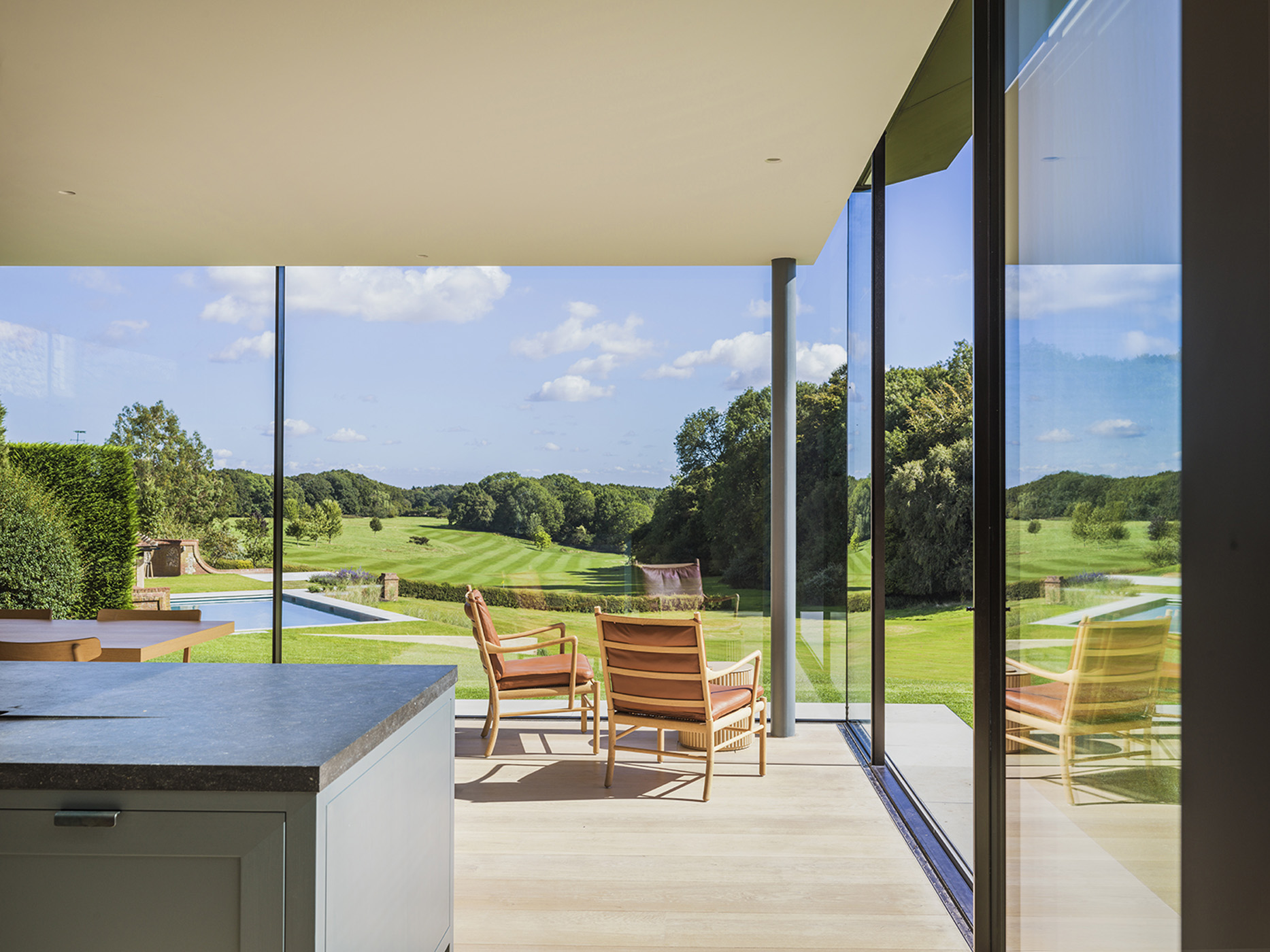 A modern glass extension provides views of landscaped grounds