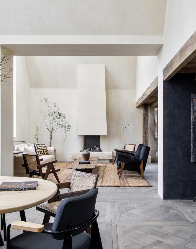 Light exposed plaster contrasts against a dark kitchen within the dramatically open-plan reception room of a luxury penthouse apartment for rent on Blenheim Crescent