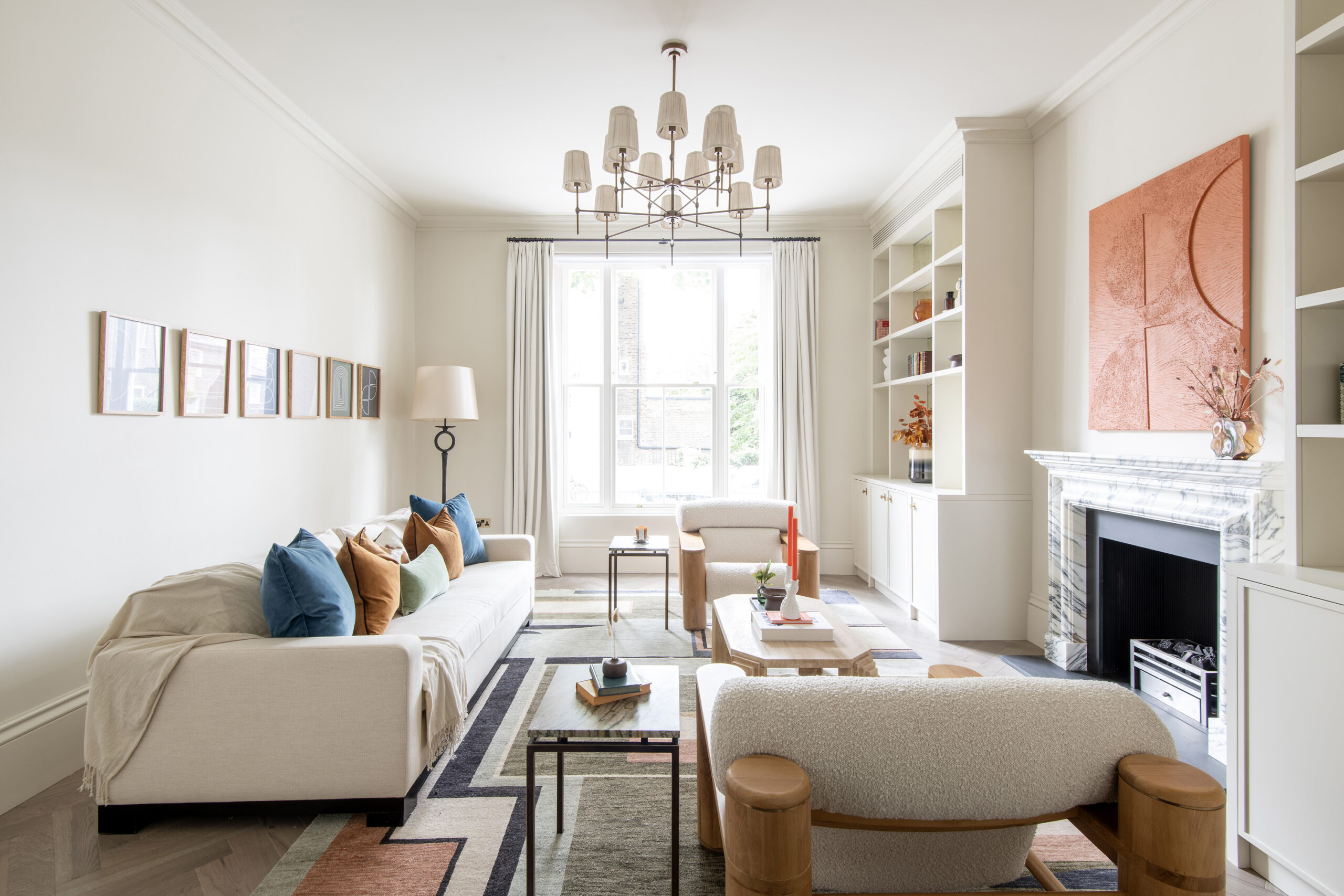 Luxury reception room with integrated bookshelves, large sash window and marble fireplace in a three-bedroom Notting Hill duplex apartment for sale