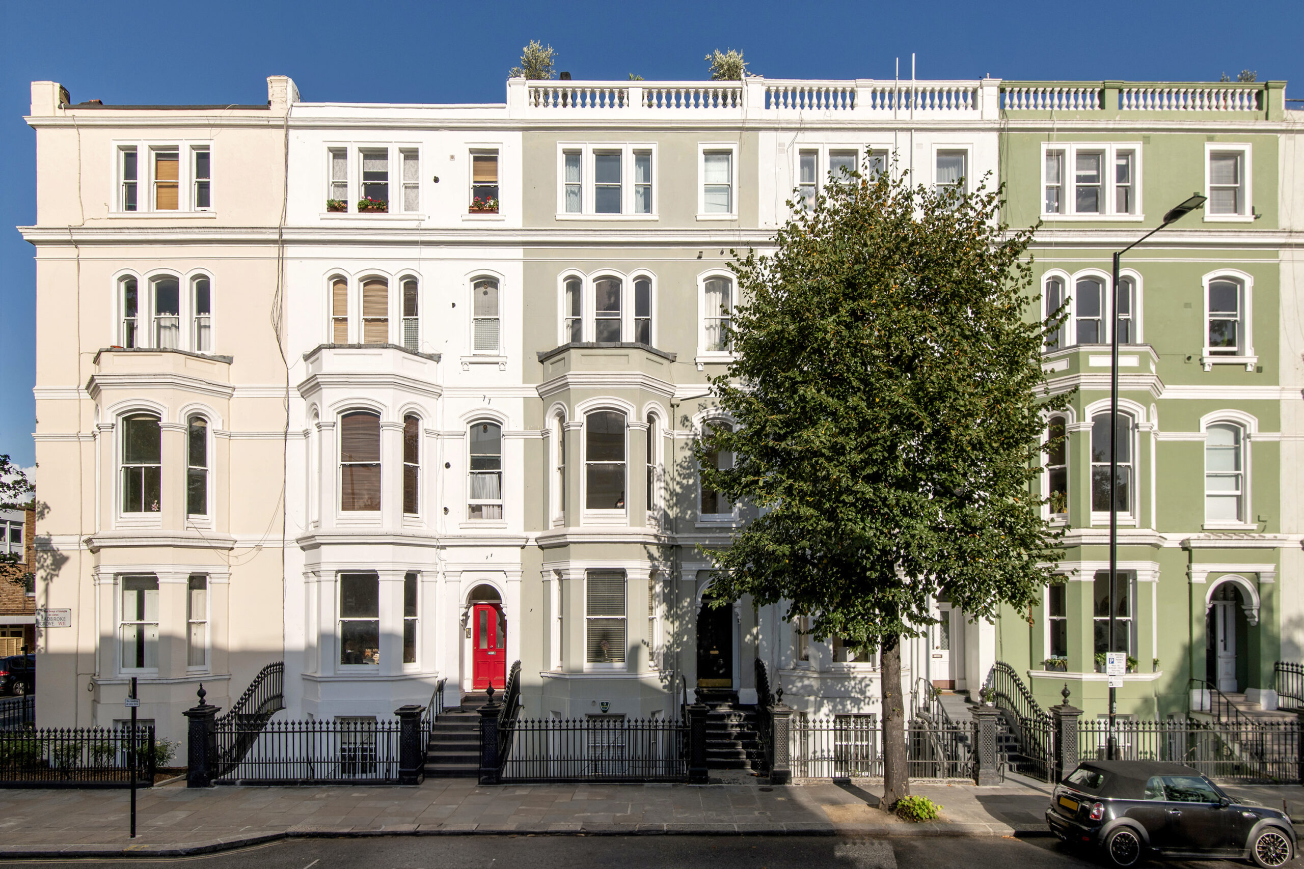 Pastel-coloured townhouse exterior of an apartment for sale in Notting Hill