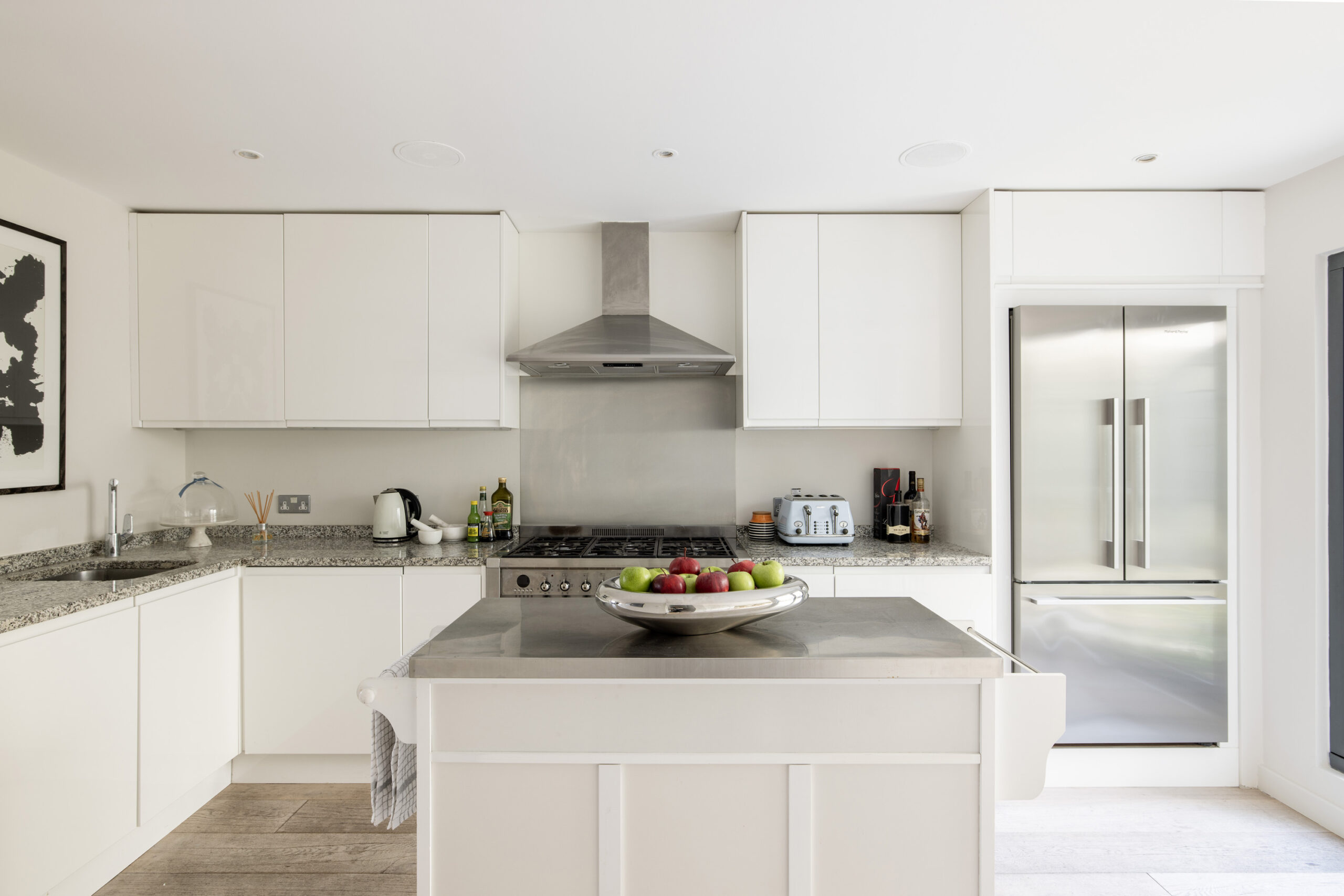 Stylish modern L-shaped kitchen with stainless steel counters in a three-bedroom mews house for sale