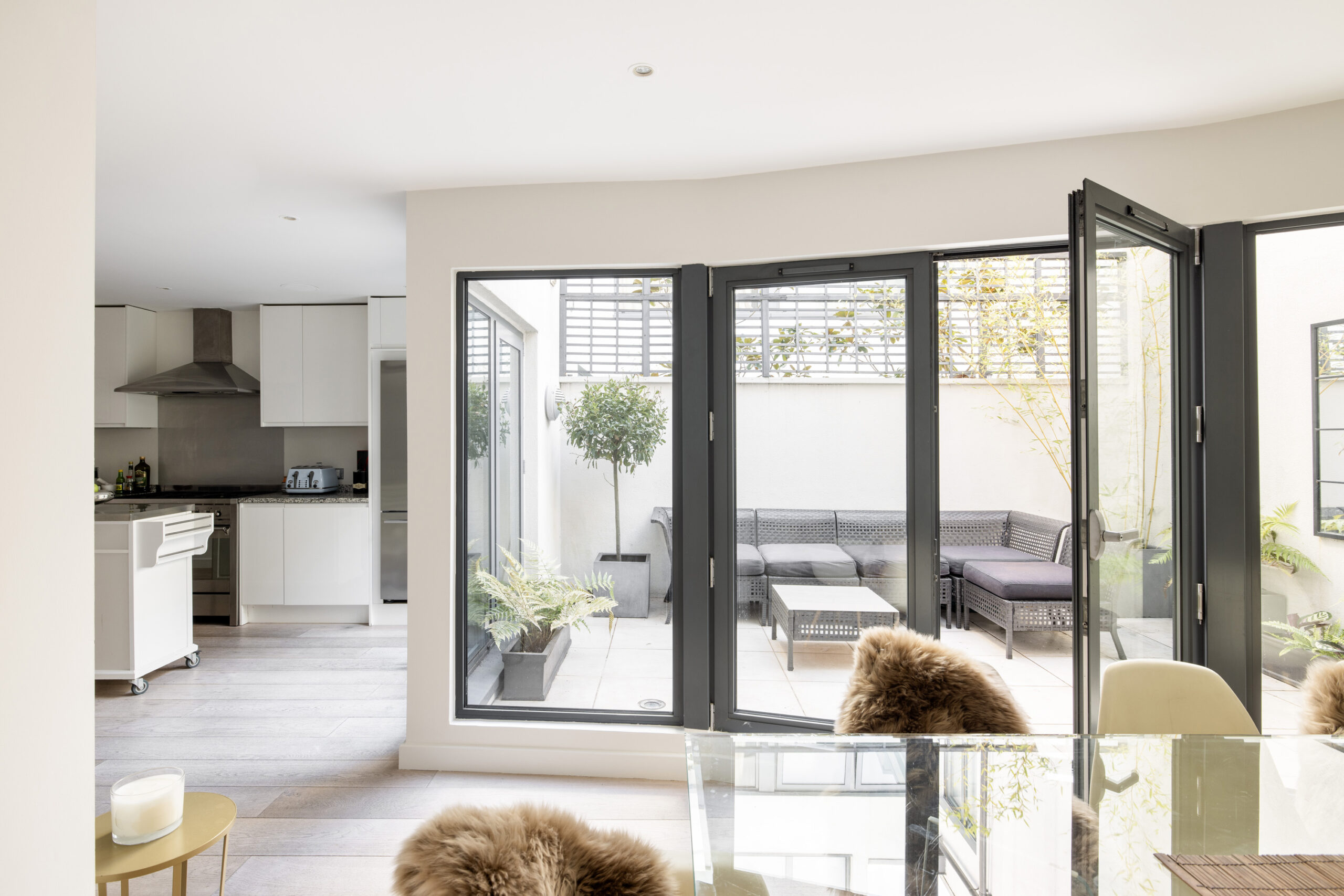 Kitchen and dining area with glass doors leading to a private garden of a three-bedroom mews house for sale in Notting Hill