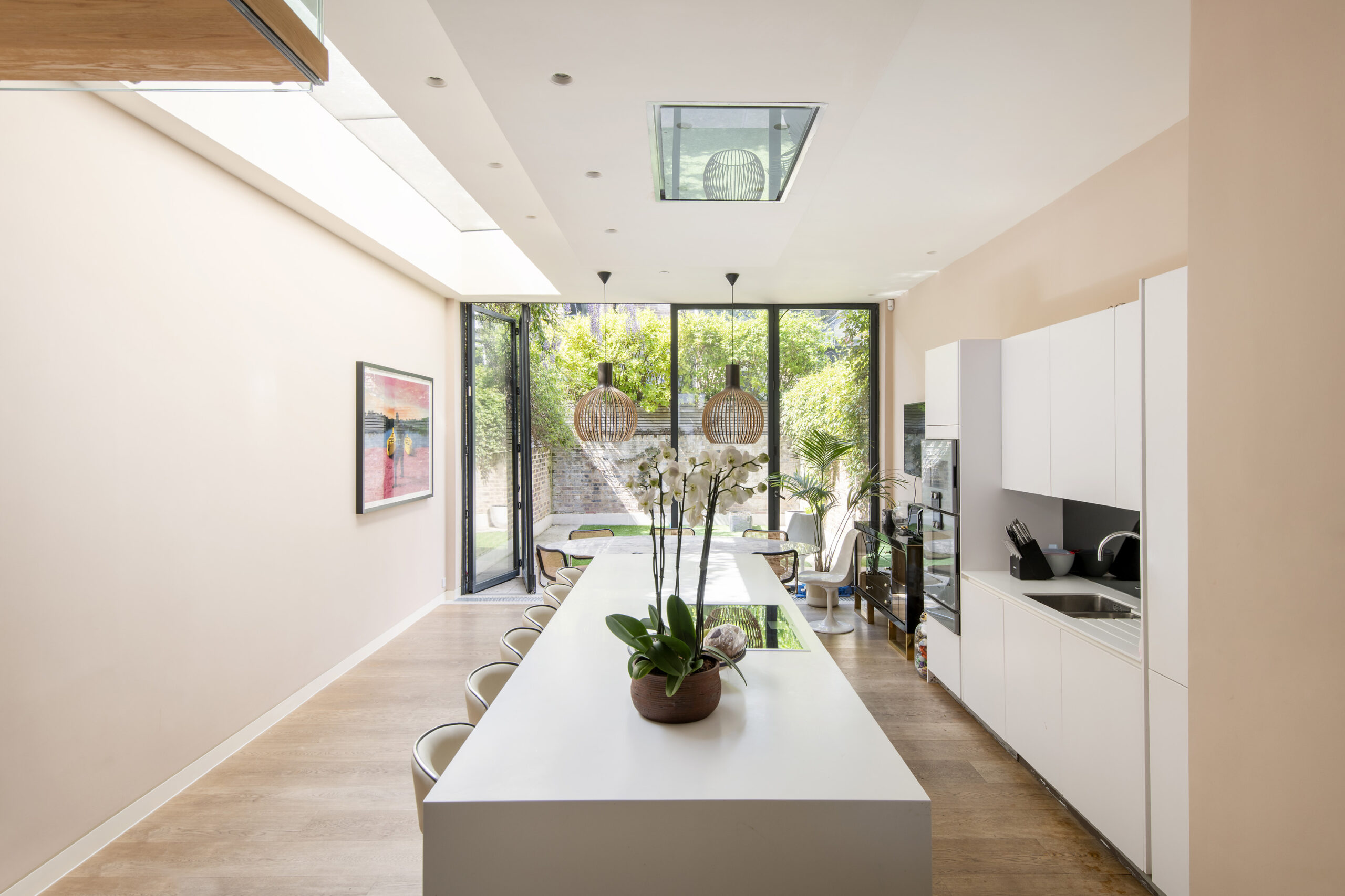 Bright contemporary kitchen with glass doors to a private garden of a four-bedroom luxury Notting Hill townhouse for sale.
