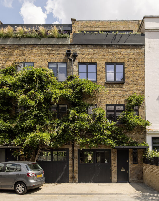 Plant covered yellow brick facade of a three-bedroom home for sale on Portobello Road