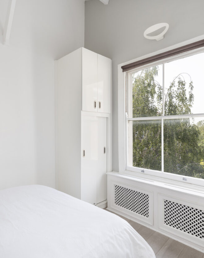 Bright bedroom of a top floor Notting Hill apartment with leafy garden views