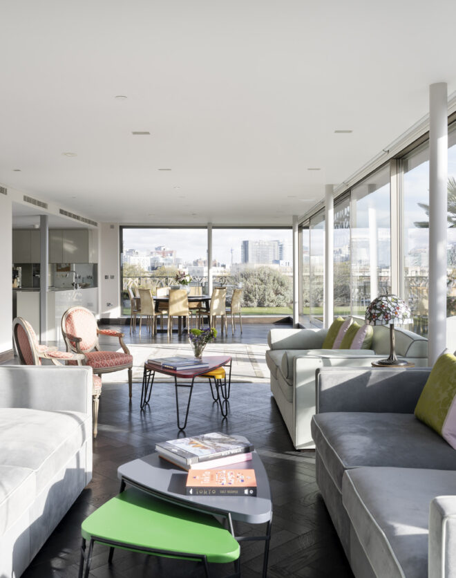 A vast open-plan living space with wraparound glazing to a roof terrace in a penthouse apartment for sale on Westbourne Grove