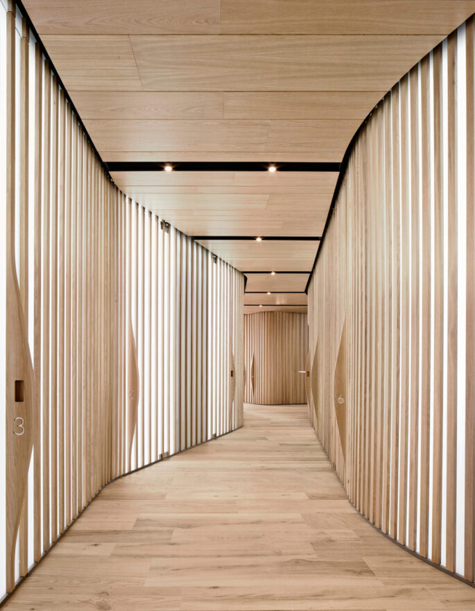 Corridor with wooden beams by OHLAB