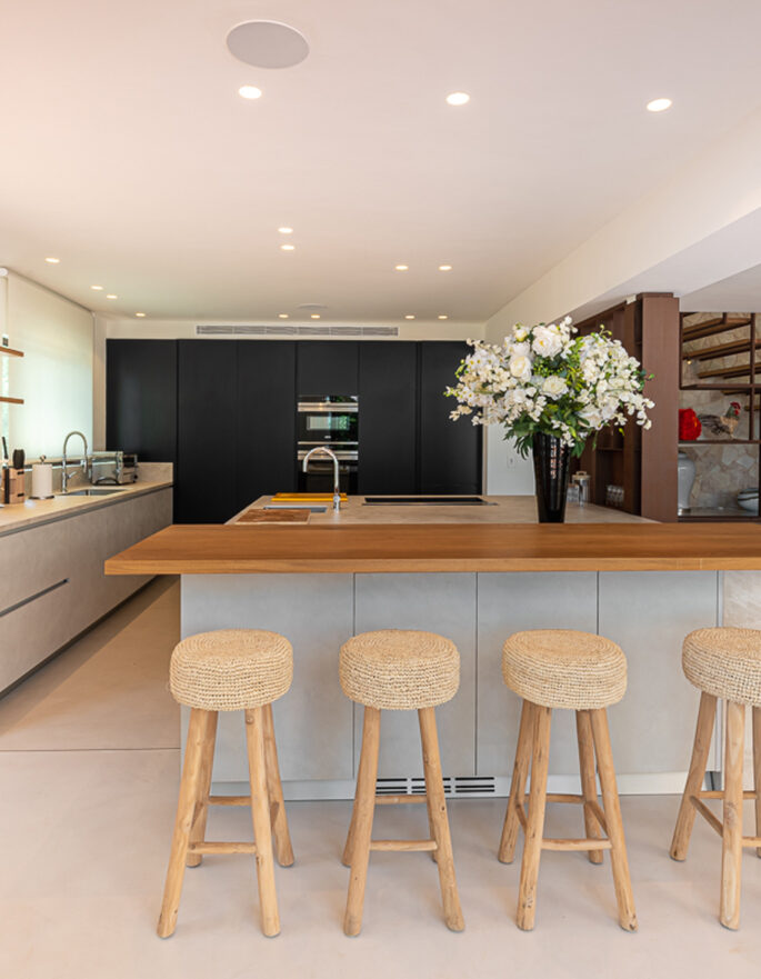 Kitchen and breakfast bar backdropped by a navy accent wall in a luxury Ibizan villa