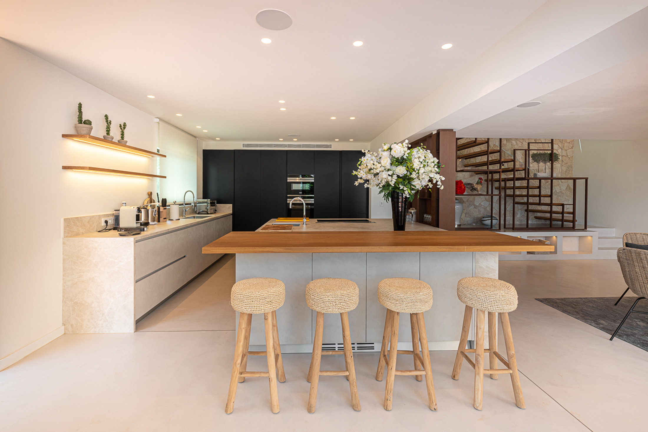 Kitchen and breakfast bar backdropped by a navy accent wall in a luxury Ibizan villa