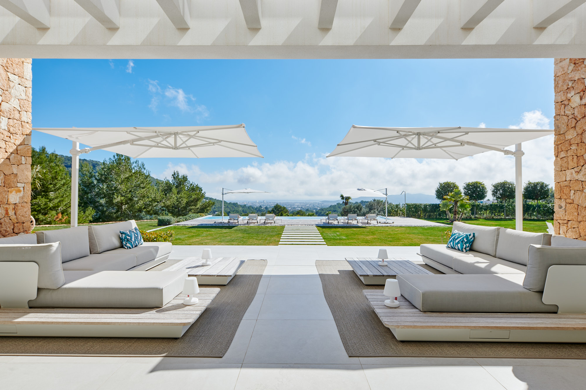 Outdoor furniture frames the view of a pool at a luxury villa to buy in Ibiza