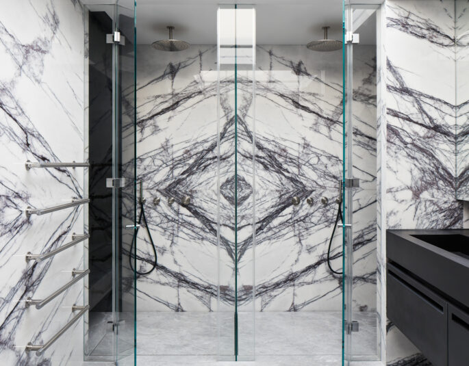 Matching cuts of marble in a contemporary bathroom create a mirrored effect