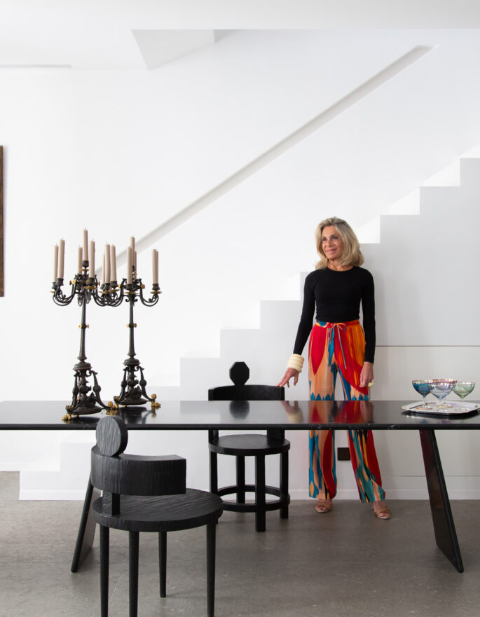 Woman stands next to a grand dining table in an Ibizan townhouse