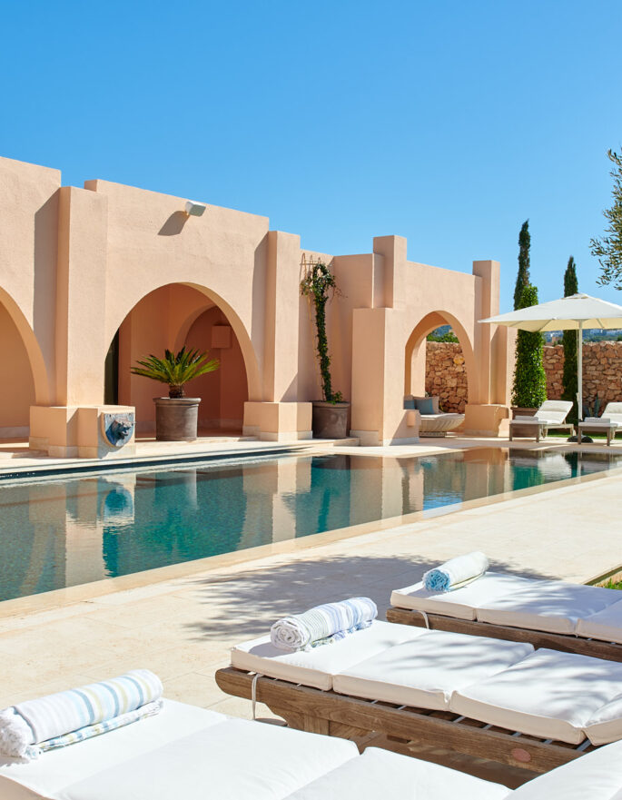 Moroccan arches reflected in the pool of a luxury holiday home in southwest Ibiza